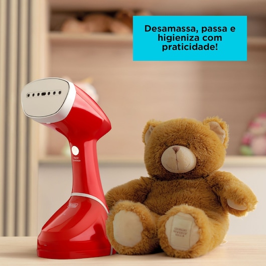 BLACKDECKER BDV2100 red handheld garment steamer next to a brown teddy bear, on tabletop.