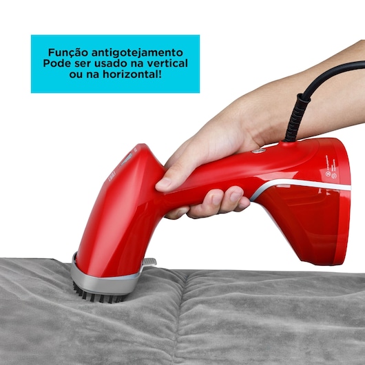 BLACKDECKER BDV2100 red handheld steamer with anti-drip feature, used horizontally on gray fabric, side angle.