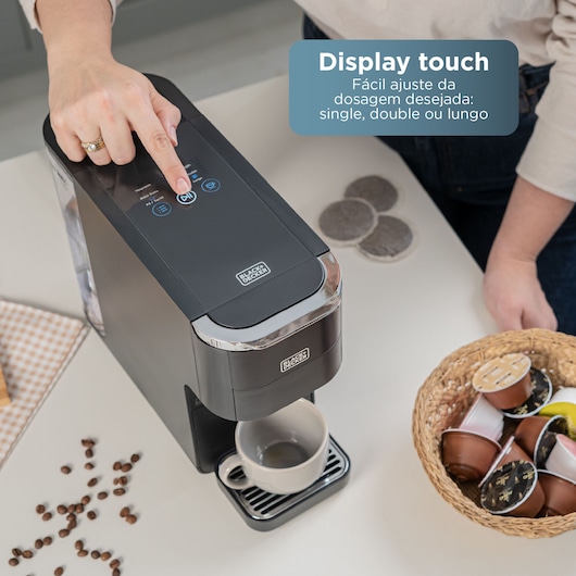 BLACK+DECKER coffee maker with touch display. Person selects settings. Basket holds coffee pods.