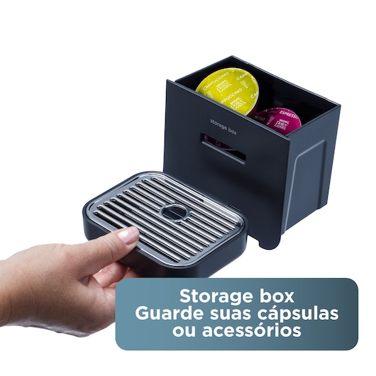 Black box for storing coffee capsules or accessories. Hand holding detachable tray. Capsules visible in box.