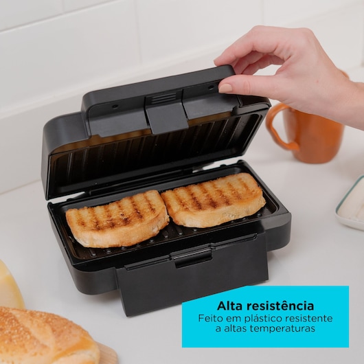 Black sandwich grill with two toasted breads inside, hand opening lid, text highlights high resistance plastic.