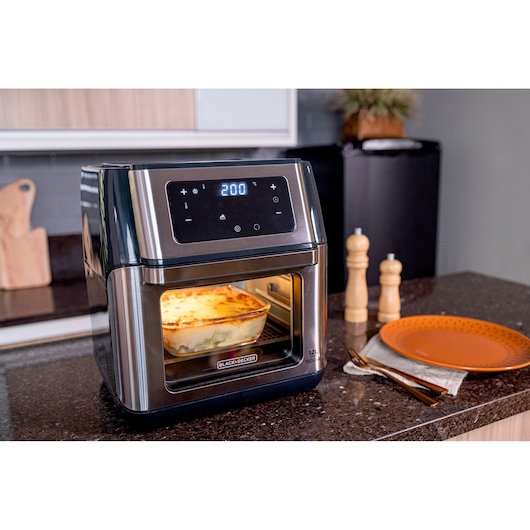 BLACKDECKER AFO12G digital air fryer oven with food inside on kitchen counter, photography.