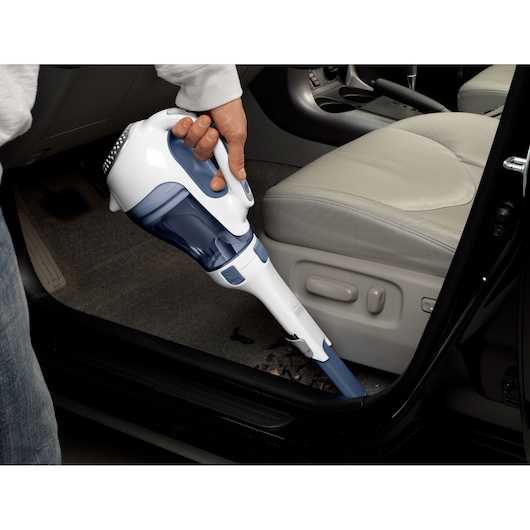 Photo of BLACKDECKER APB12000 handheld vacuum cleaner with blue accents cleaning car interior floor.