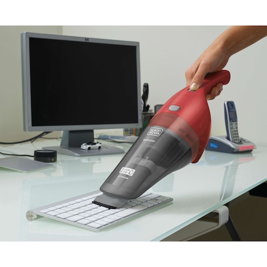 BLACKDECKER APB3600 handheld vacuum cleaning a keyboard in an office setting.