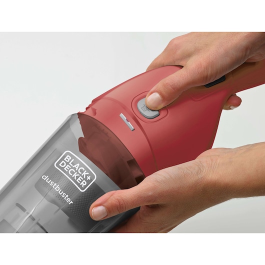BLACK+DECKER APB3600 red handheld vacuum cleaner held in hand, close-up of power button and dust container.