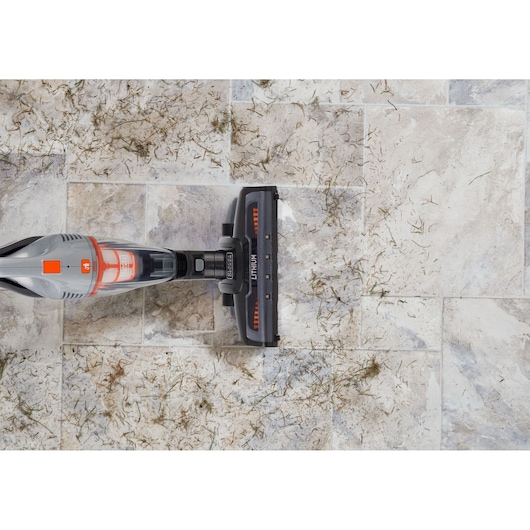 BLACKDECKER AV160 cordless vacuum cleaner top view cleaning debris on light tile floor.