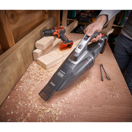 BLACKDECKER BCHV001D1E handheld vacuum cleaner used on a workbench with wood shavings, drill, and wood pieces.