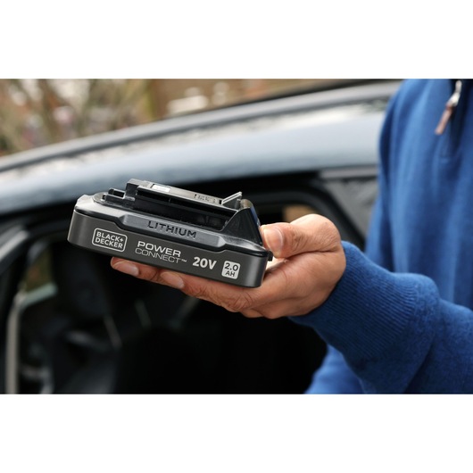 Hand holding the power connect battery on a blurred background