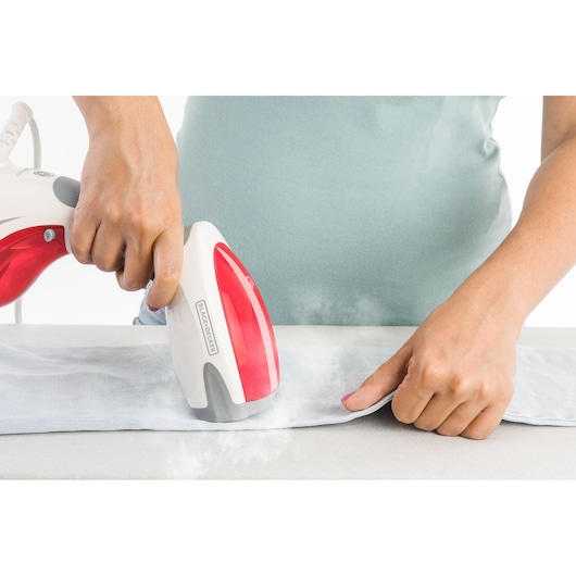 Photo of BLACK+DECKER BDV2000V handheld garment steamer in use on a light fabric, front angle.