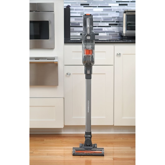 Photo of BLACKDECKER BHFEA18D1 cordless stick vacuum cleaner standing upright on a kitchen floor, front view.