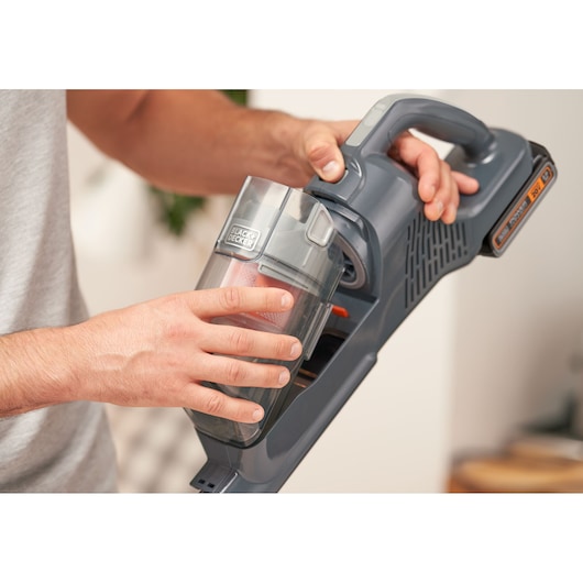 Photo of BLACKDECKER BHFEA18D1 cordless vacuum in gray with transparent dust container being held by hand.