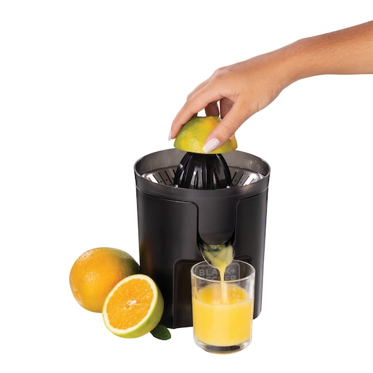Photo of BLACKDECKER CJ1000 electric citrus juicer with a hand pressing an orange, fresh juice in glass, whole and sliced orange.