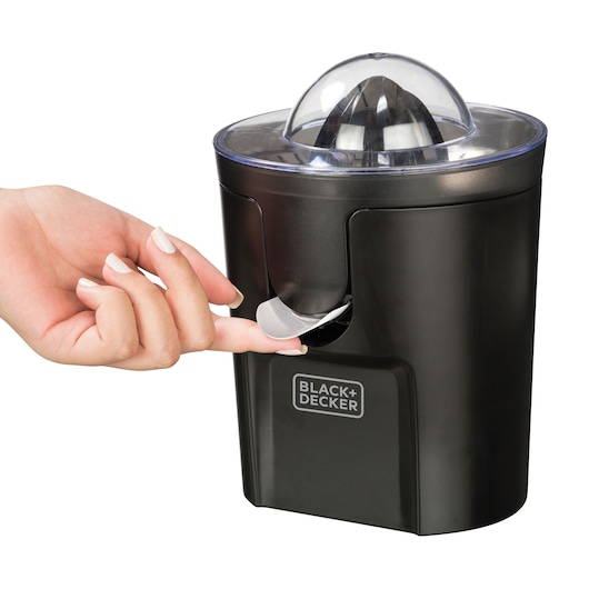 Photo of BLACK+DECKER CJ1000 black citrus juicer with a hand lifting the spout, white background.