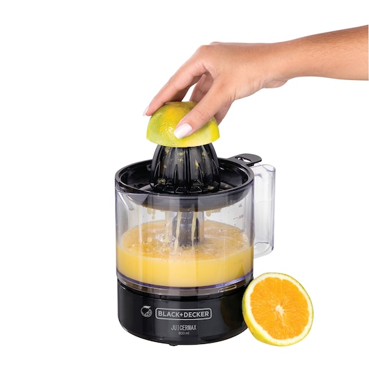 Photo of BLACK+DECKER CJ700 electric citrus juicer extracting juice from orange, clear container, side angle.