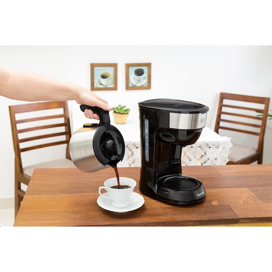 Photo of BLACKDECKER CM38 coffee maker on a kitchen table with coffee being poured into a white cup.