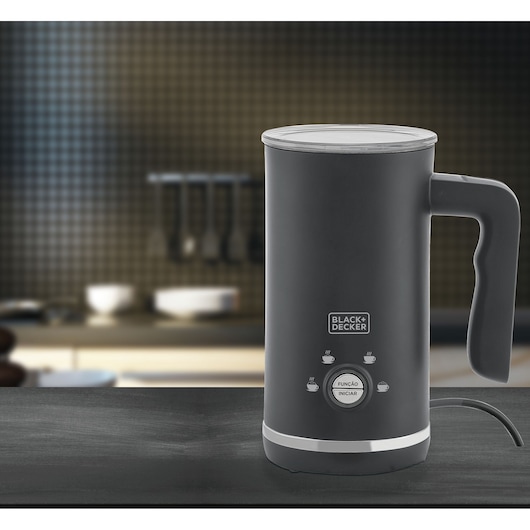 BLACK+DECKER electric milk frother EL500, shown on a kitchen counter. The frother is cylindrical, has a black body, a handle, and labeled buttons for different functions.