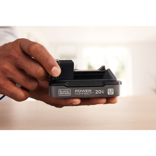 a man's hand holding a battery