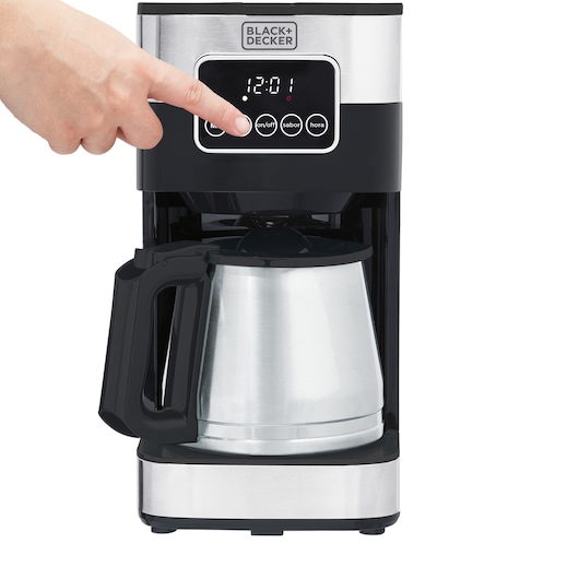 Programmable electric coffee maker, with a front view, with one finger selecting one of the on/off options on the panel