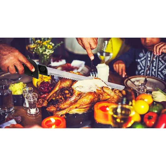 BLACKDECKER FEL150 electric knife slicing cooked turkey on festive table with candles and vegetables.