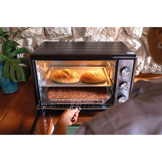 BLACKDECKER FT46 countertop oven with two loaves of bread and a tray of brownies inside, door open.