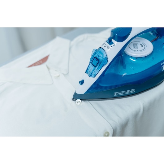 Photo of BLACKDECKER FX2150 blue steam iron pressing a white shirt, close-up, product category photography.