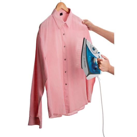 BLACKDECKER FX3060 steam iron used on a pink shirt, front angle, shirt on hanger.