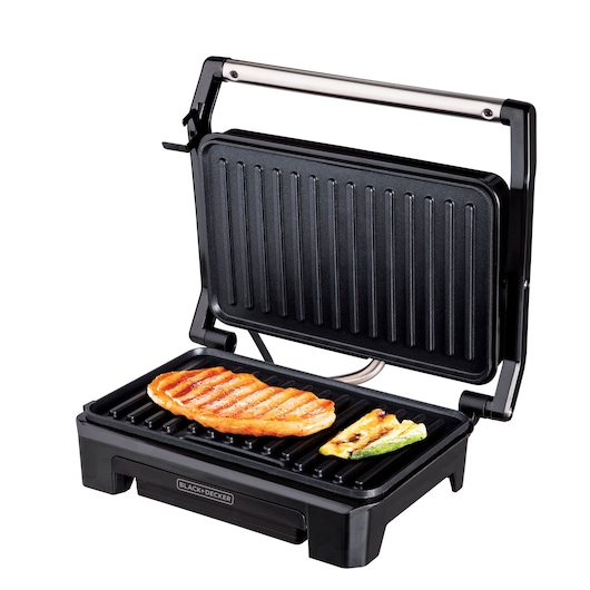 A BLACK+DECKER electric grill with an open lid, grilling a piece of meat and some vegetables on the ridged cooking surface.
