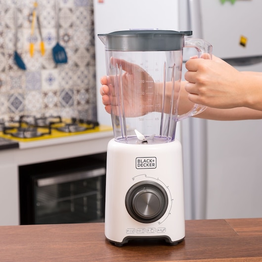 Photo of BLACKDECKER L800 blender with clear jar and black lid on kitchen counter, hand holding handle.