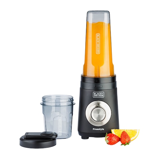 A BLACK+DECKER freestyle blender with a tall blending cup filled with orange liquid, a separate smaller cup, a lid, and slices of strawberries and orange beside it.