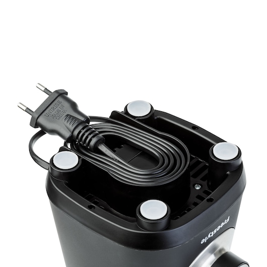 Close-up view of the bottom of a BLACK+DECKER appliance showing a wrapped power cord and plug. Four round rubber feet are visible for stability.