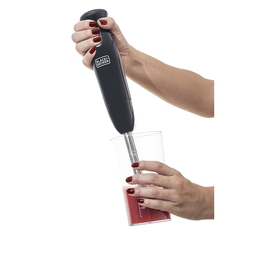 Photo of BLACK+DECKER M300 hand blender in use, blending red liquid in clear measuring cup, side angle.