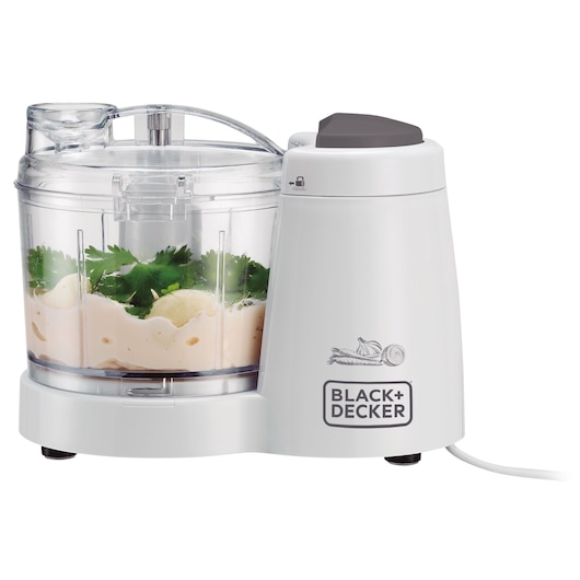 BLACK+DECKER MP120 white food processor with transparent bowl, herbs and sauce inside, side angle on white background.