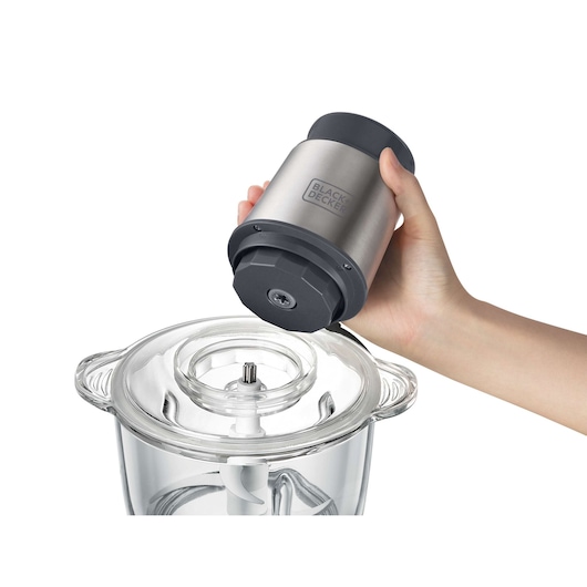 Photo of BLACKDECKER MP300G food processor motor being placed on clear glass bowl, close-up view.