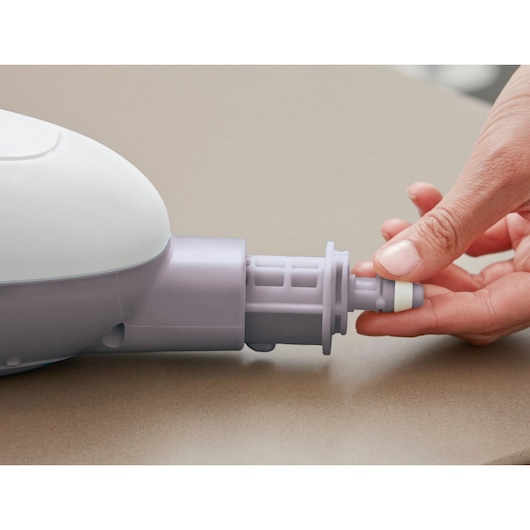 BLACKDECKER VL1300 hand holding light gray accessory attachment for cleaning device, close up view.