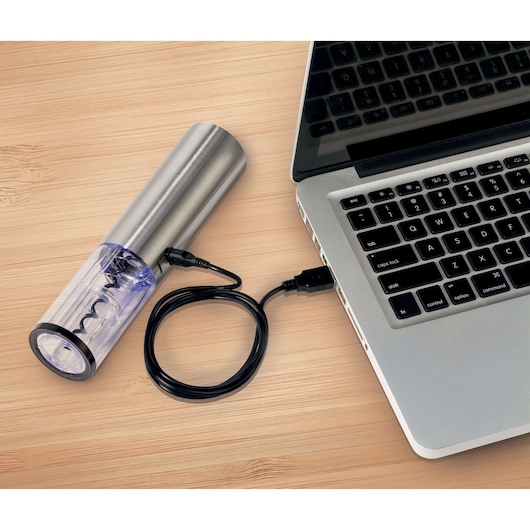 BLACKDECKER W10 electric corkscrew connected to a laptop via USB cable on wooden surface.